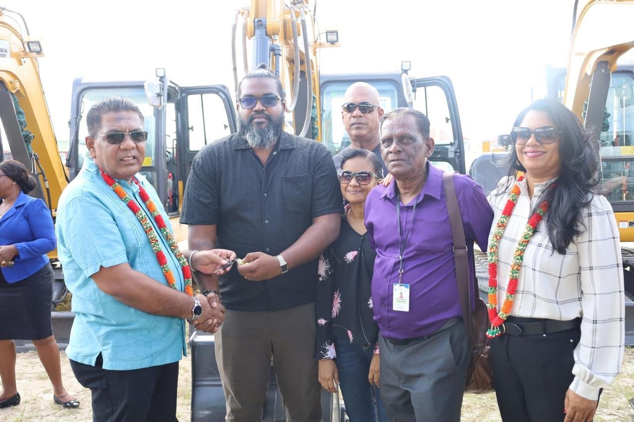 Agriculture Minister Zulfikar Mustapha hands over the keys to one of the excavators to an NDC representative as Local Government Minister Sonia Parag and other local government officials look on