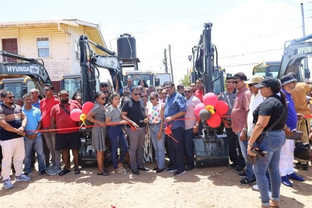 Minister Mustapha assists in cutting the ceremonial ribbon to officially handover the mini-excavators