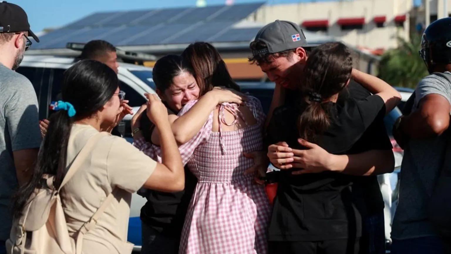 People cry and hug each other near the Jet Set nightclub in Santo Domingo