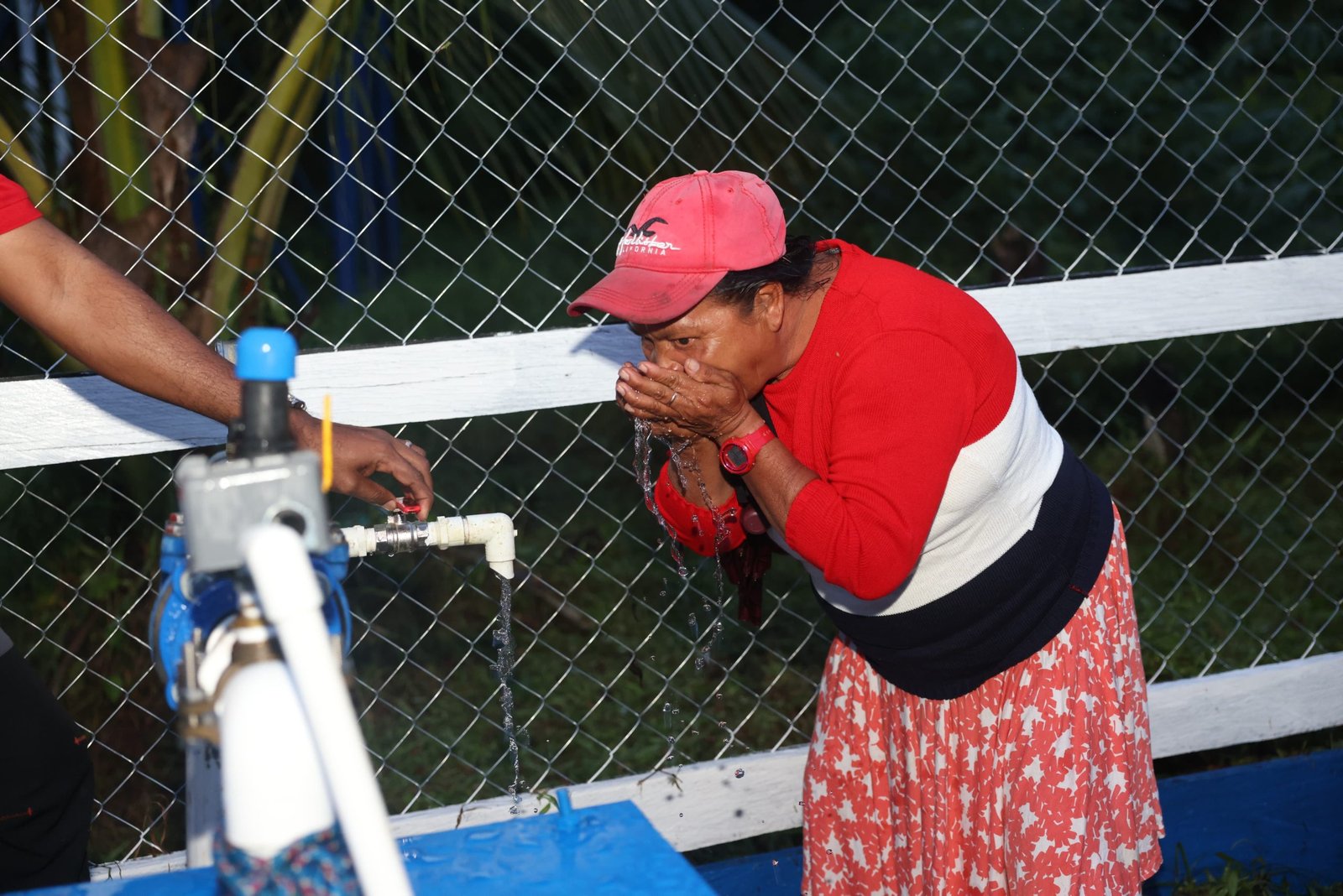 A resident drinks water from the new system