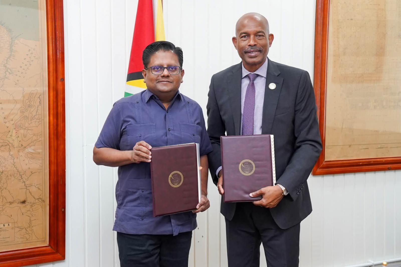 Minister Singh and Mr Soomer display the agreement (Ministry of Finance photo)