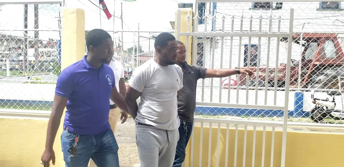 Caption: Alfred De Jonge being led away by detectives