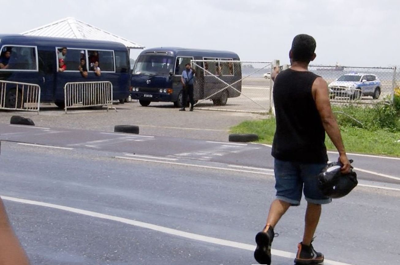 A Coast Guard sentry motions to a Venezuelan national (Trinidad and Tobago Guardian)